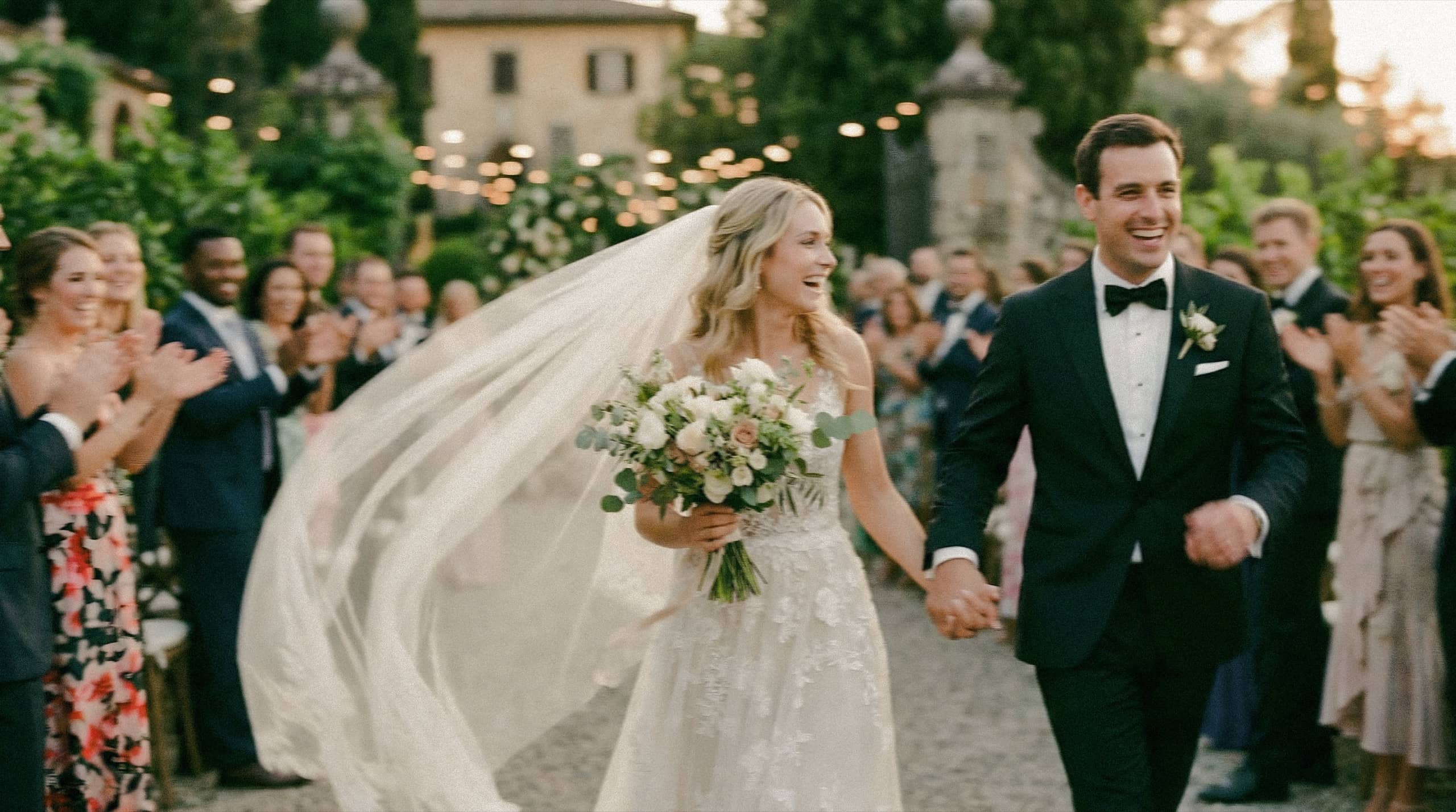 Novios saliendo de la ceremonia de la mano entre invitados que aplauden