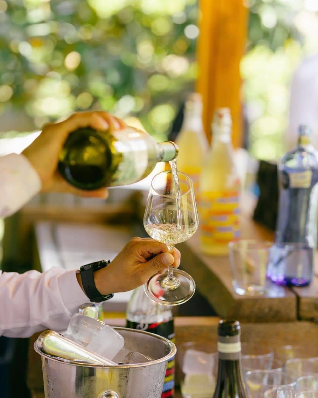 Camarero sirviendo vino blanco en una copa