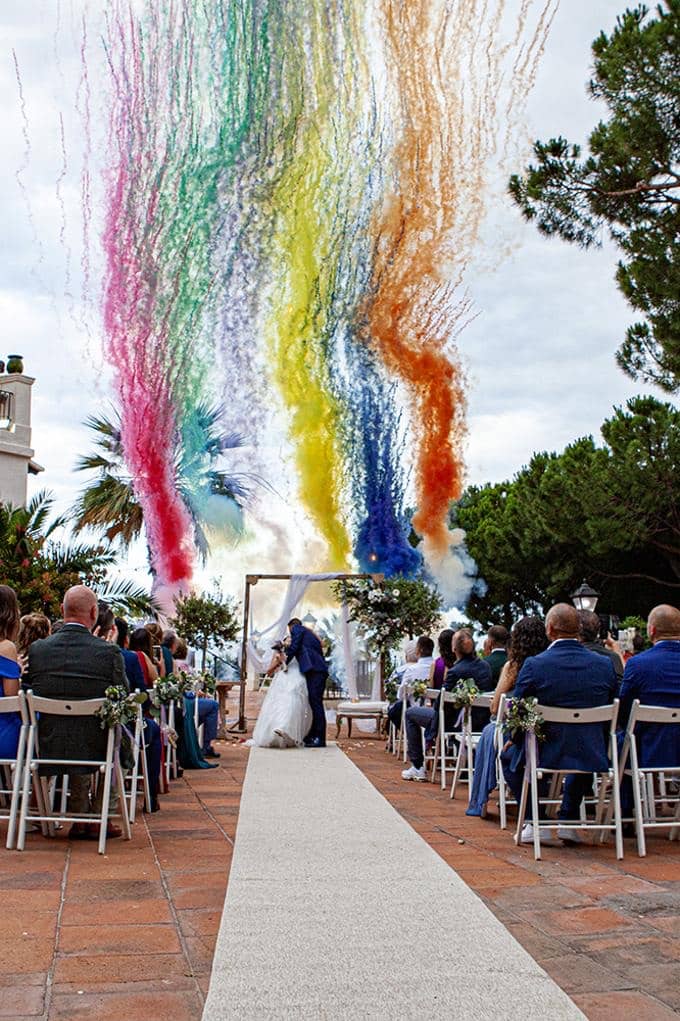 Ceremonia al aire libre con humo de colores sobre el pasillo